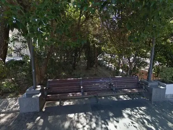 Detrás de los bancos en el jardín de Plaza de Colón